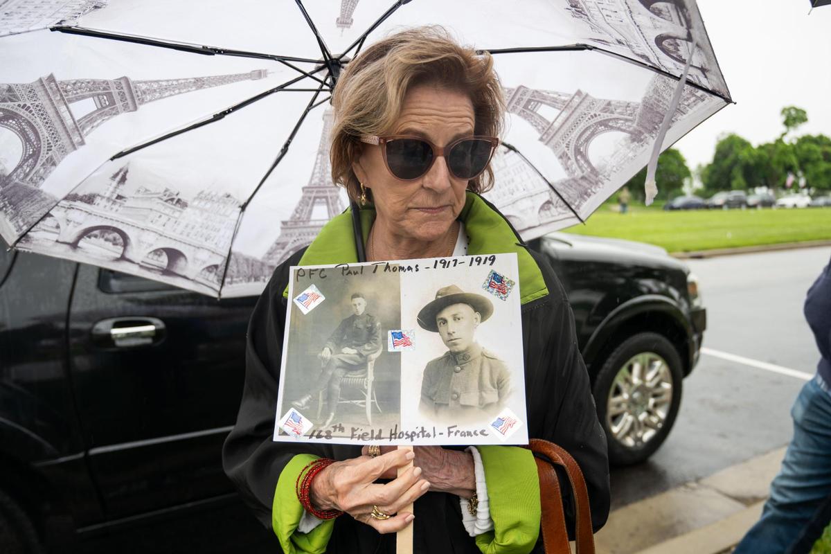 Paula Bingham holds up a sign with photos of her father, PFC Paul Thomas of the Rainbow Division, following the Walk of Honor Dedication Ceremony at the WWI Museum and Memorial on Monday, May 26, 2025.