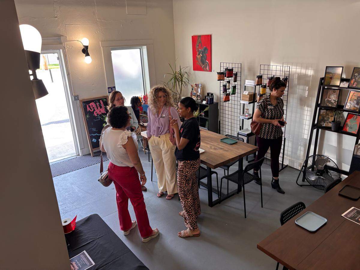 Visitors talk with Remy Wharry inside Raw Art Studio during the studio’s opening celebration. The space includes original artwork, Raw Art Paints, retail items and room for workshops.