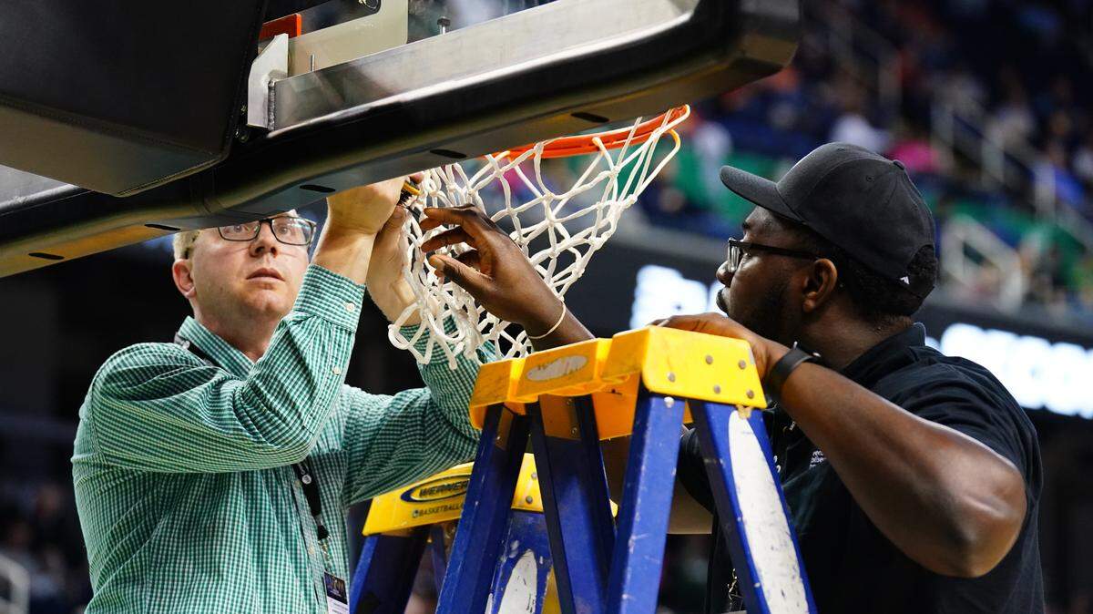 Staff work to adjust the basket before the game between the Iowa State Cyclones and the Pittsburgh Panthers at Greensboro Coliseum on March 17, 2023.