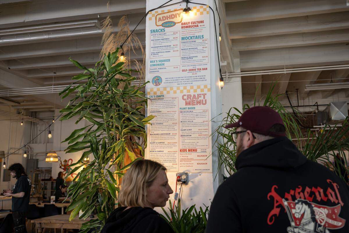 Guests look at the ADHDIY Craft Cafe menu near the entrance on Saturday, Feb. 7, 2026, in Kansas City.