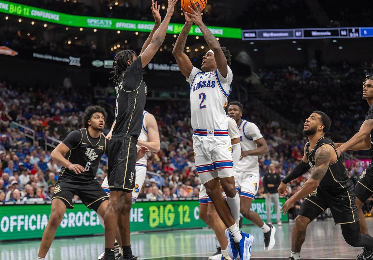 Kansas Jayhawks guard AJ Storr (2) shoots as UCF Knights guard Tyler Hendricks (15) defends in the second half at the Big 12 Tournament at T-Mobile Center on Wednesday, March 12, 2025, in Kansas City.