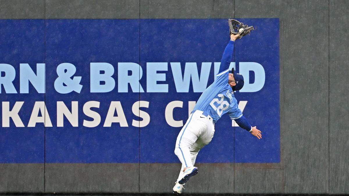 Kansas City Royals center fielder Kyle Isbel (28) makes a leaping catch against the Toronto Blue Jays George Springer in the fifth inning at Kauffman Stadium.
