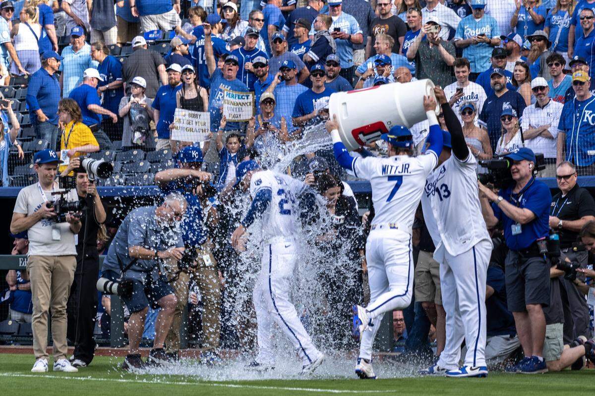 Kansas City Royals center fielder Kyle Isbel (28) is doused by shortstop Bobby Witt Jr. (7) and catcher Salvador Perez (13) after hitting a two-run homer in the home opener against the Minnesota Twins at Kauffman Stadium on Monday, March 30, 2026, in Kansas City.