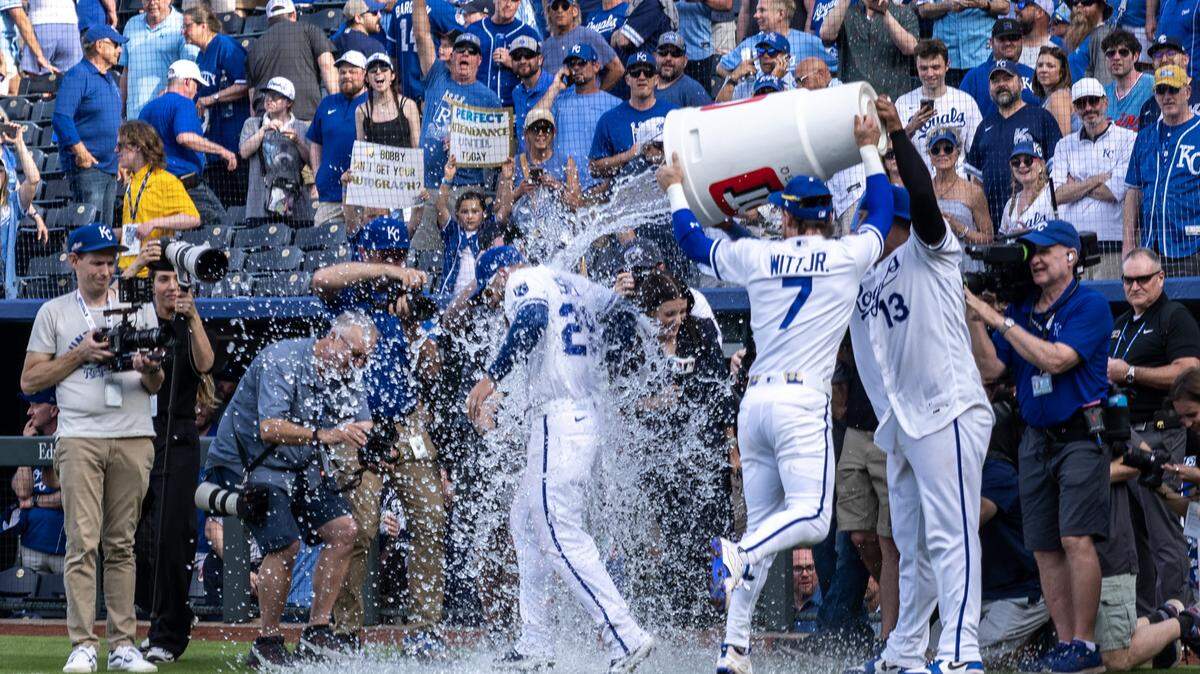 Kansas City Royals center fielder Kyle Isbel (28) is doused by shortstop Bobby Witt Jr. (7) and catcher Salvador Perez (13) after winning 3-1 for for an home opening game against the Minnesota Twins at Kauffman Stadium on Monday, March 30, 2026, in Kansas City.