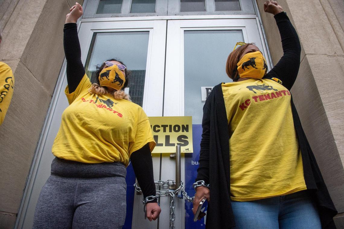 Magda Werkmeister, left, and Tiana Caldwell, members of KC Tenants, chained themselves to the doors of the Jackson County Courthouse in downtown Kansas City Thursday.