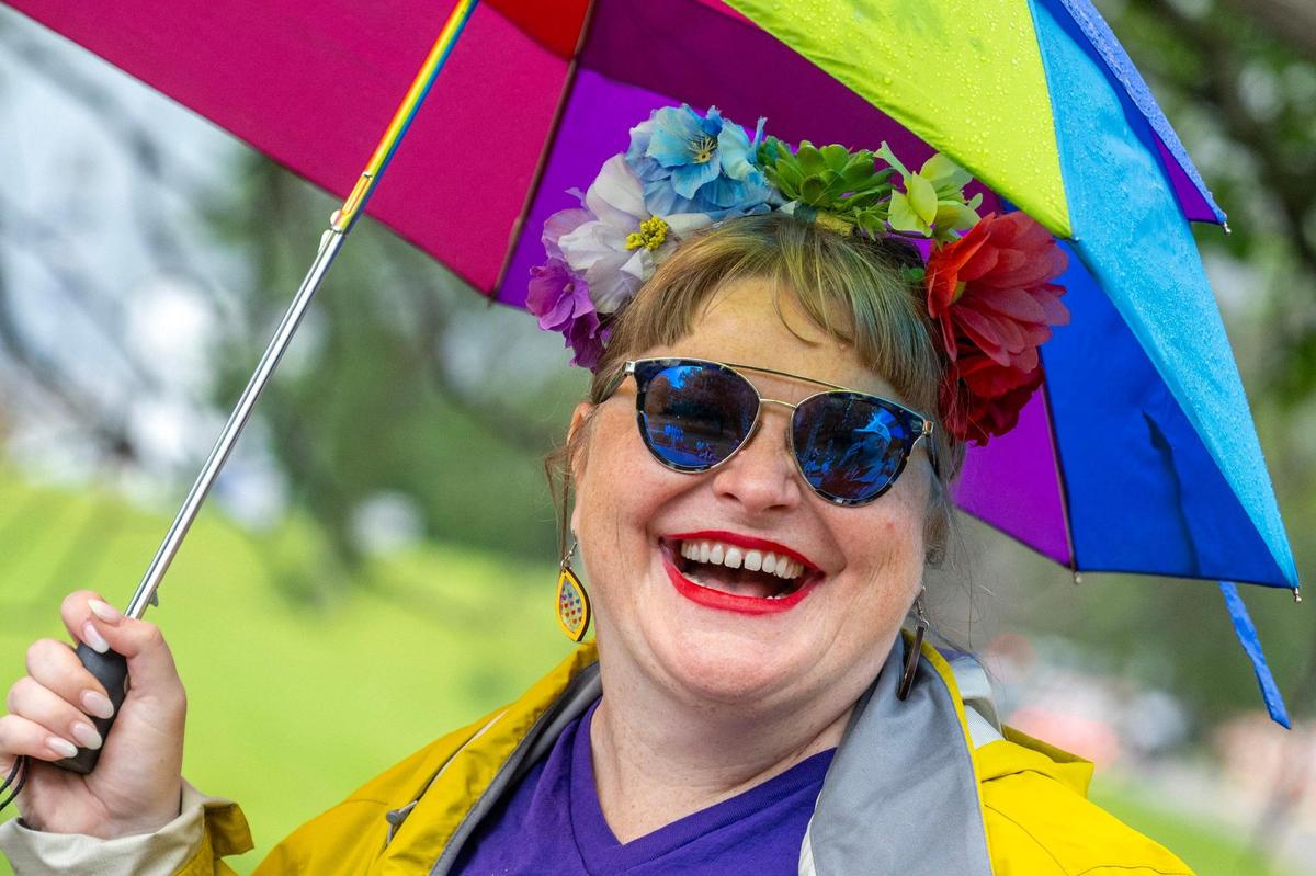 A parade participant adorned with a flower crown smiles as they walk down Mill Creek Parkway during the KC Pride Parade on Saturday.