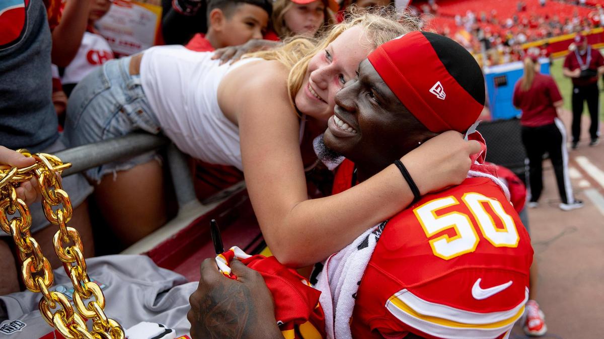 Kansas City Chiefs linebacker Willie Gay (50) embraces a fan while posing for a photo after the Chiefs defeated the Cleveland Browns 33-32 in an NFL preseason football game on Saturday, Aug. 26, 2023, in Kansas City.