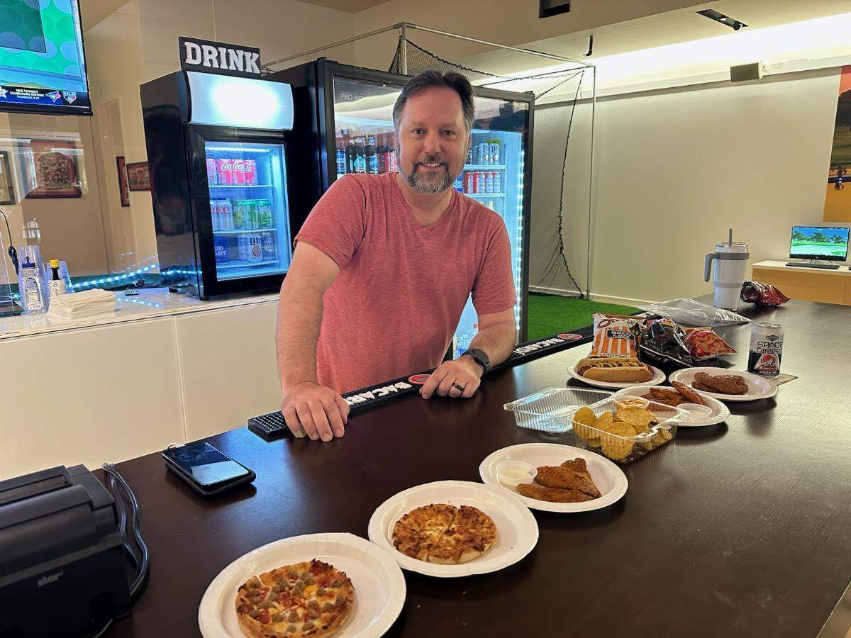 Ryan Marshall with some of the food selections at the new AME Golf & Brew Lounge.