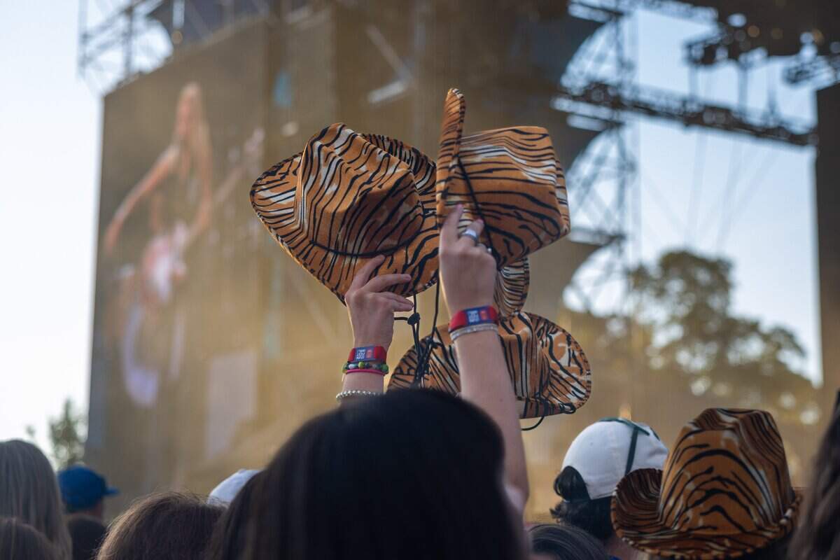 Tiger striped cowboy hats are held in the air during the Sheryl Crow FIFA Fan Fest concert at Fan Fest on Friday, July 10, 2026.