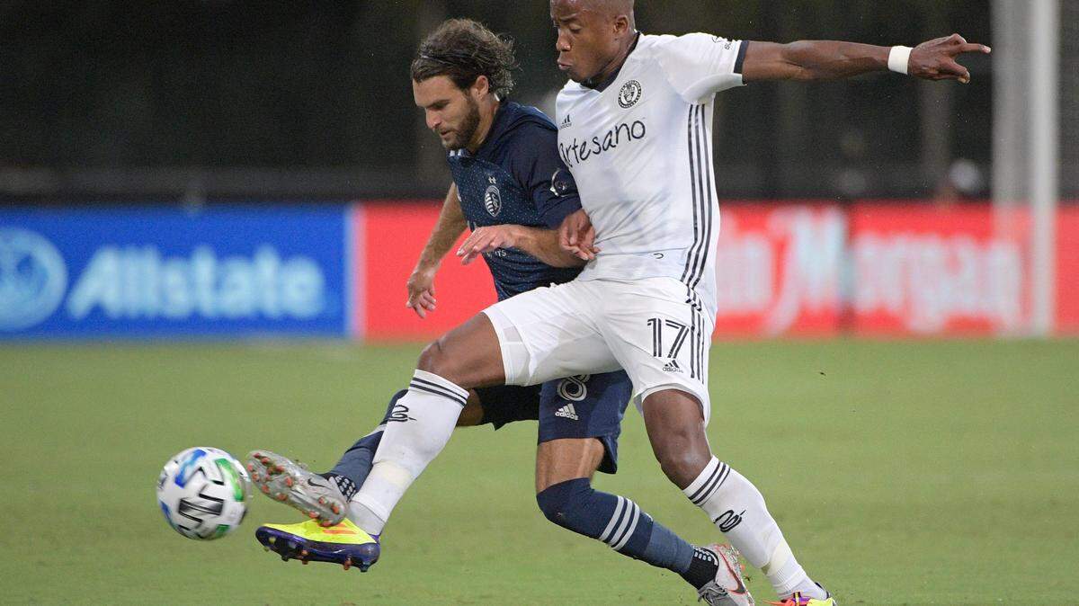 Philadelphia Union forward Sergio Santos (17) and Sporting Kansas City midfielder Graham Zusi compete for a ball during the first half of an MLS soccer match Thursday, July 30, 2020, in Kissimmee, Fla. (AP Photo/Phelan M. Ebenhack)