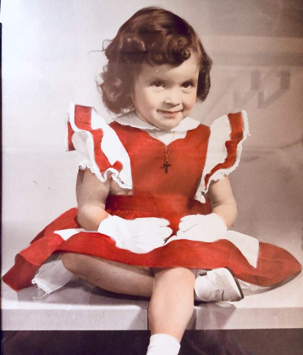 A young Suzanne O'Malley sits on a Formica table in her parents' kitchen in Kansas City.