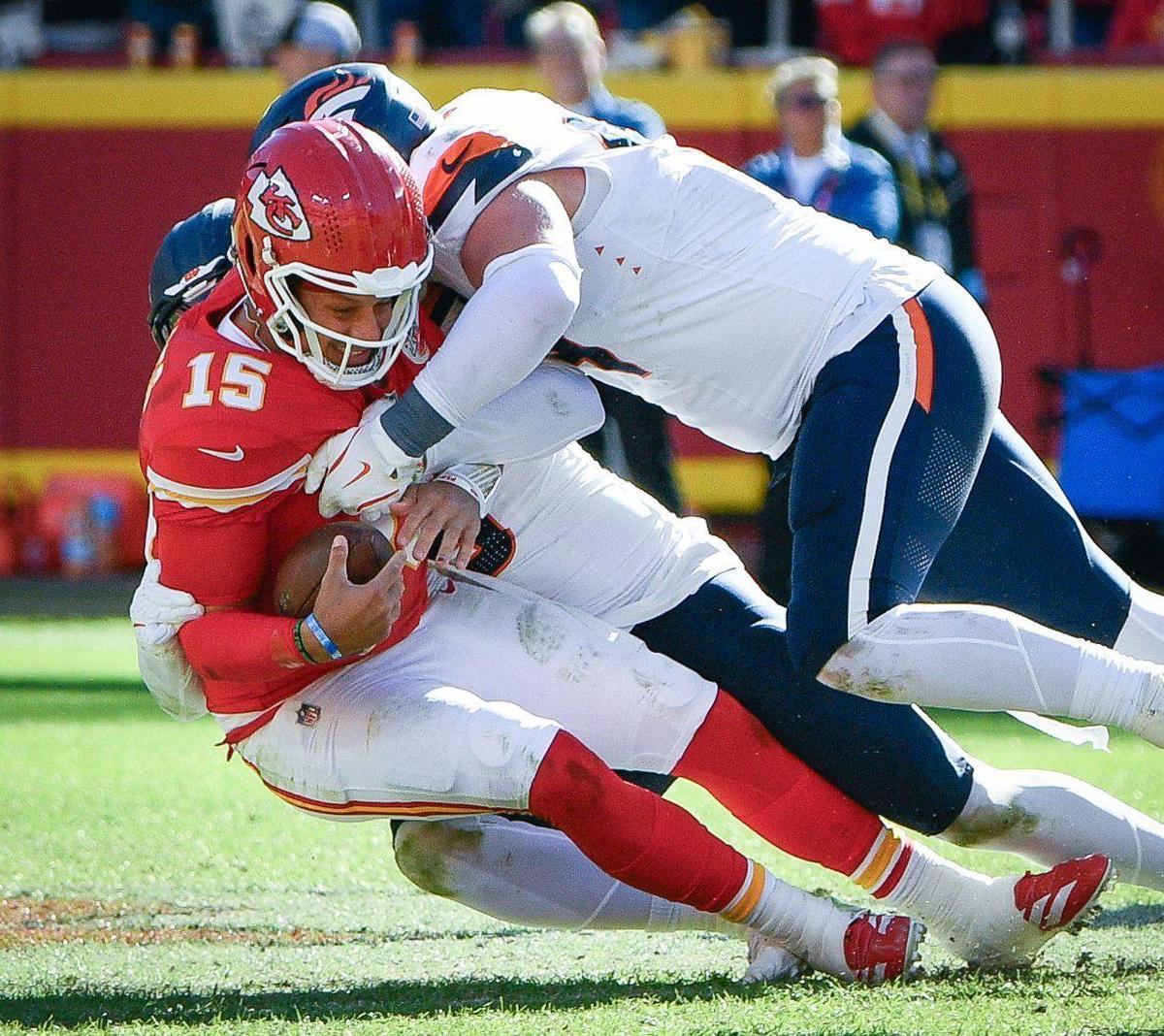 Kansas City Chiefs quarterback Patrick Mahomes (15) is sacked by Denver Broncos defenders in the first half on Sunday, Nov. 10, 2024, at GEHA Field at Arrowhead Stadium.