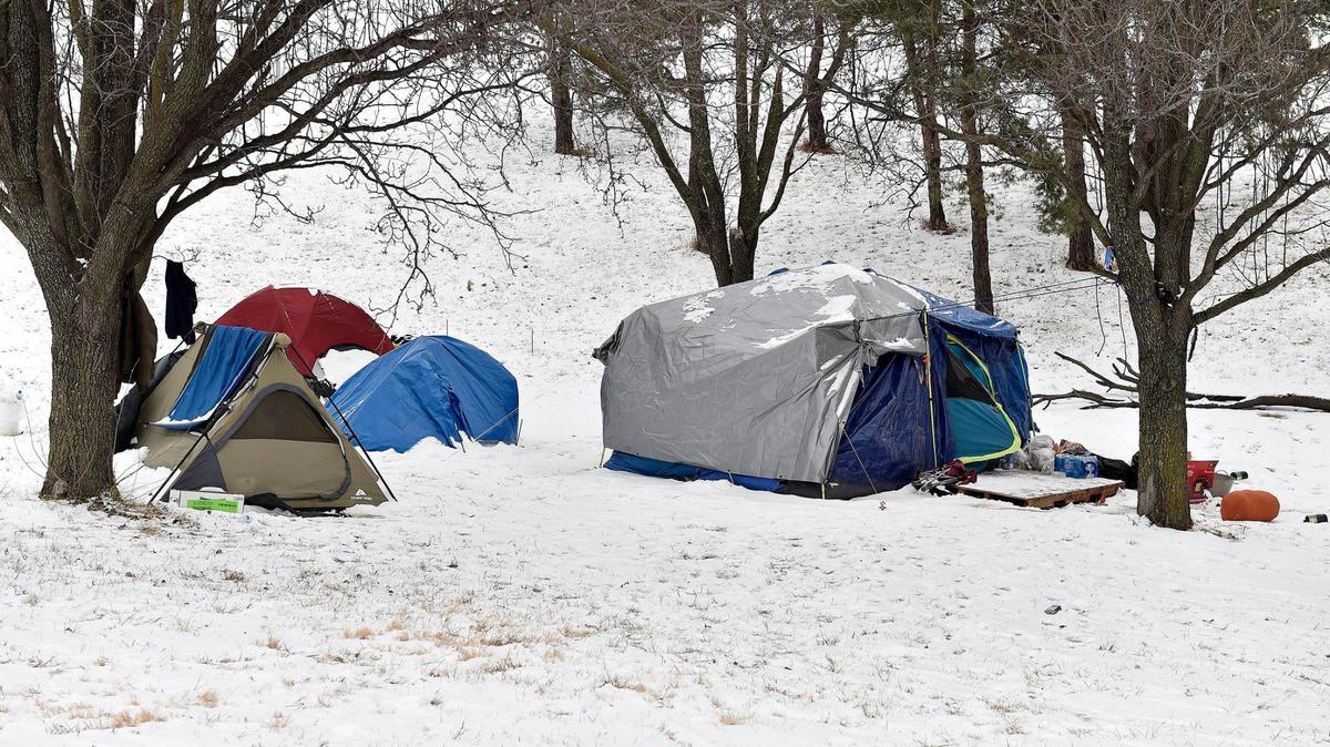 People without homes set up camp along a highway off ramp, seen Wednesday, Feb. 10, 2021.