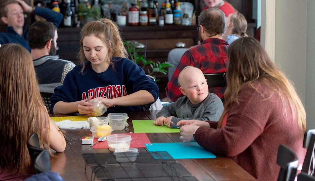 Crosby Orlando, a Shawnee Mission special education student, listens to his aunt Amanda Simmons as their family makes cookies in Prairie Village.