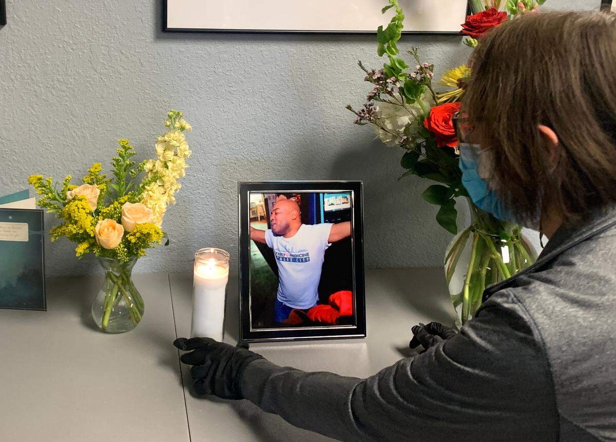 Cora Zamora, director of nursing at Street Medicine KC, stands in front of a memorial for Jae Edgar Bennett during the Saturday clinic. Bennett died unexpectedly this week, the organization announced Friday morning.