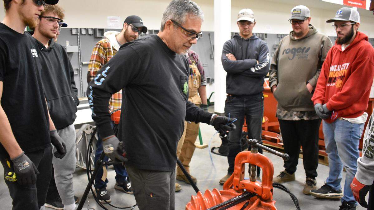 Instructor Steve Morales demonstrates how to bind electrical wires to a class of first-year apprentices, including Jacob King (far right), at the Electrical Joint Apprenticeship and Training Center in Kansas City on Wednesday, Nov. 16, 2022.