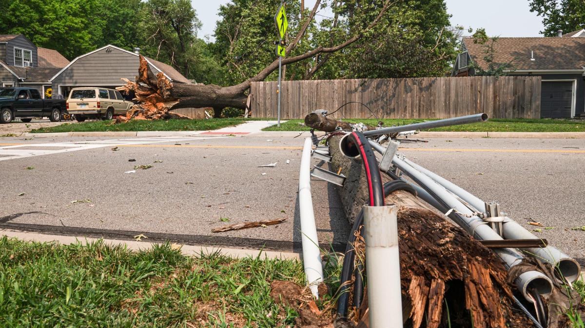 A fallen utility pole blocks Roe Avenue on Saturday, July 15, 2023, in Prairie Village. As of 1:30 p.m., just under 65,000 residents in the Kansas City area were without power.