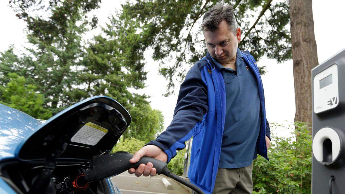 Patrick Connerâ€™ shows how to plug his Nissan Leaf electric car at a charging station at the public library in Hillsboro, Ore., Tuesday, May 19, 2015. Fuel-efficient, hybrid and electric cars are a boon for the environment, but their growing popularity means shrinking fuel tax revenues for state coffers and less money to pay for road and bridge projects. Oregon is about to embark on a first-in-the-nation program that aims to address this shortfall by testing the feasibility of taxing motorists not for the fuel they use, but for the miles they drive.