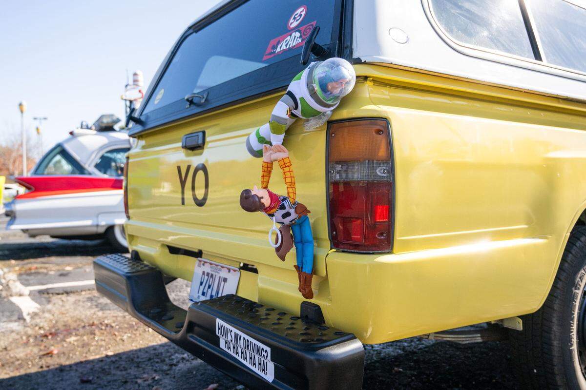 “Toy Story” characters Buzz Lightyear and Woody hang off the back of a faithful reproduction of the Pizza Planet truck seen in the movie.