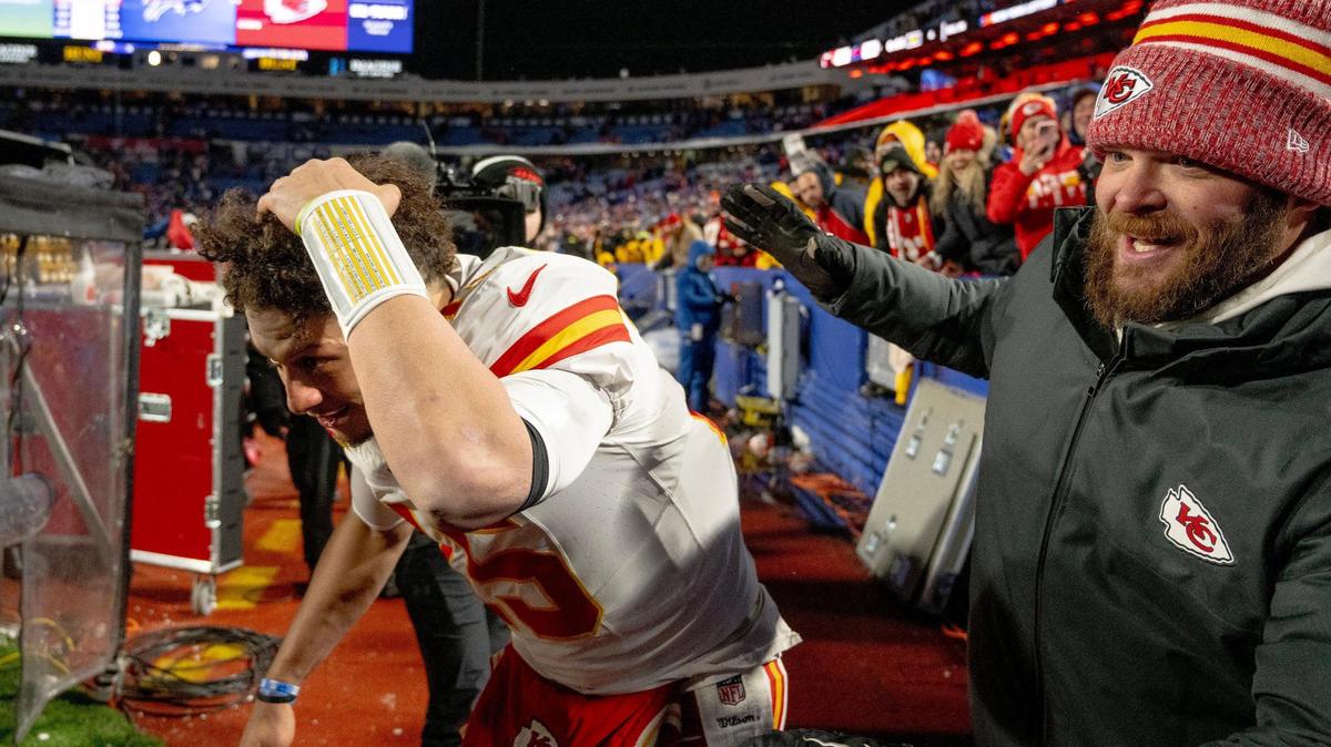 Kansas City Chiefs quarterback Patrick Mahomes (15) runs off the field while shielding himself from snowballs after the Chiefs defeated the Buffalo Bills 27-24 during an AFC Divisional Round playoff game at Highmark Stadium on Sunday, Jan. 21, 2024, in Orchard Park, New York.