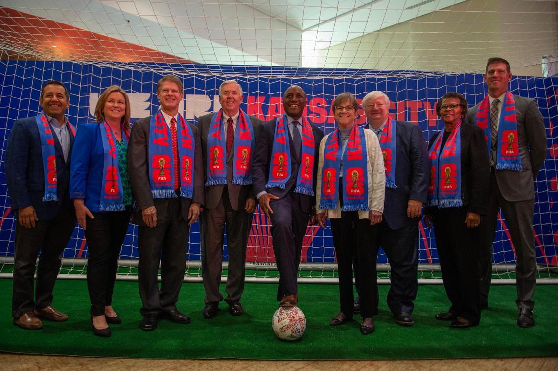 Government and civic officials pose for photos after a FIFA 2026 World Cup news conference at Arrowhead Stadium.