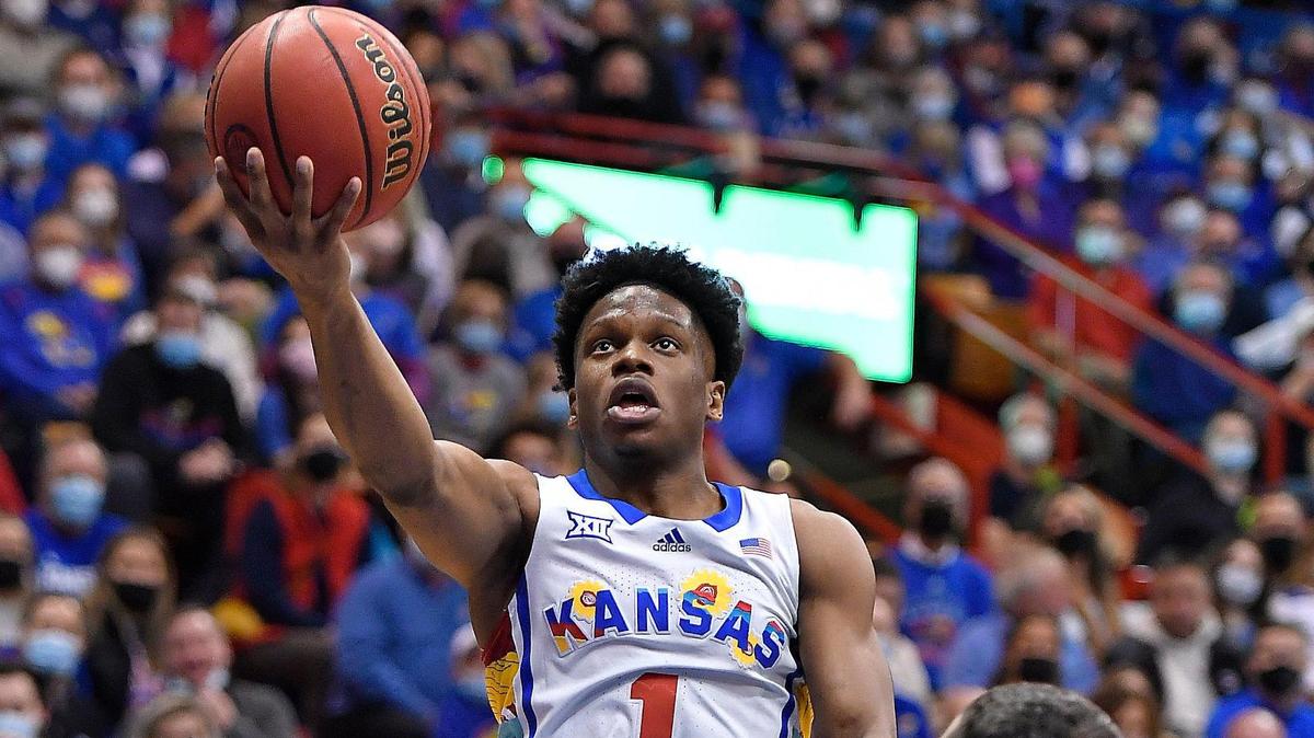 KU’s Joseph Yesufu sails past KSU’s Markquis Nowell, rear, and Ismael Massoud for a bucket during the first half of Tuesday night’s Big 12 Conference game at Allen Fieldhouse.