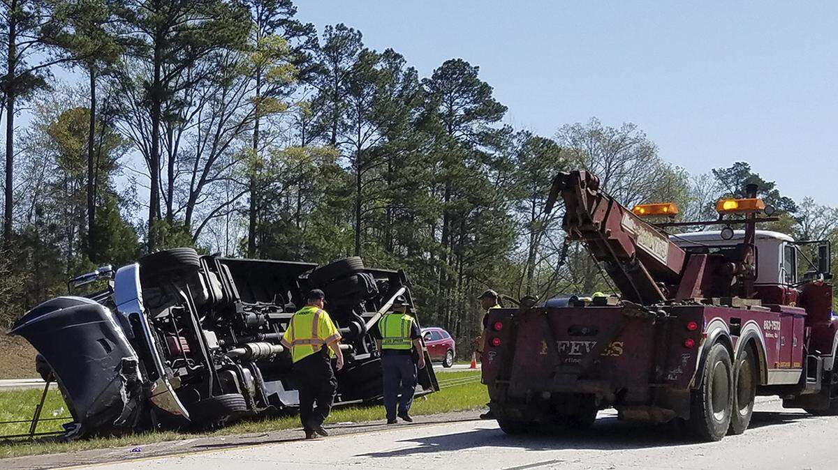 Police officers and emergency workers examine the scene of the accident scene on April 5, 2018, after a tour bus heading to the Masters golf tournament overturned along Interstate 20 near Augusta, Ga. Authorities say at least a dozen people were injured and the bus driver Steven Hoppenbrouwer was charged with DUI.