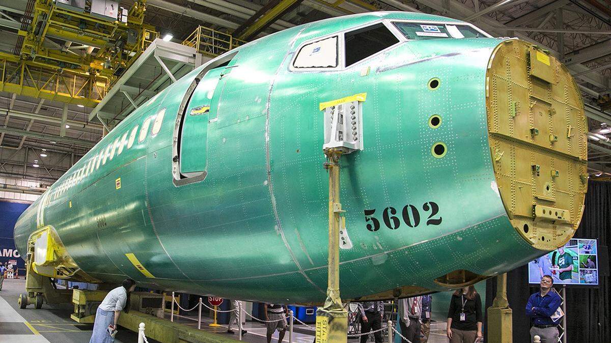 Spirit AeroSystems employees look over the first completed fuselage of the 737 MAX in 2015.