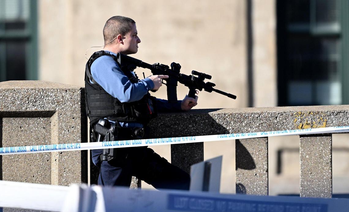 A police officer keeps his service rifle at the ready after a shooting following the Kansas City Chiefs Super Bowl LVIII victory parade on Wednesday, Feb. 14, 2024, in Kansas City.