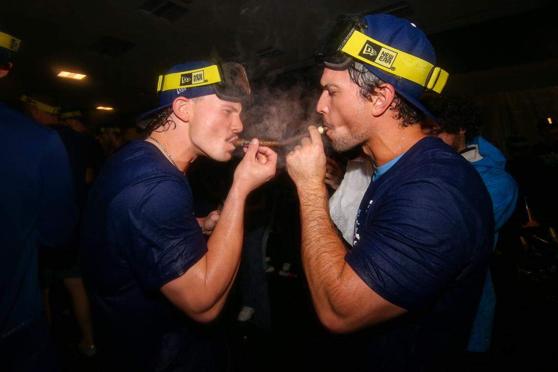Kansas City Royals shortstop Bobby Witt Jr. (7) and second baseman Adam Frazier (26) celebrate after clinching a wild card playoff birth after a game against the Atlanta Braves at Truist Park.