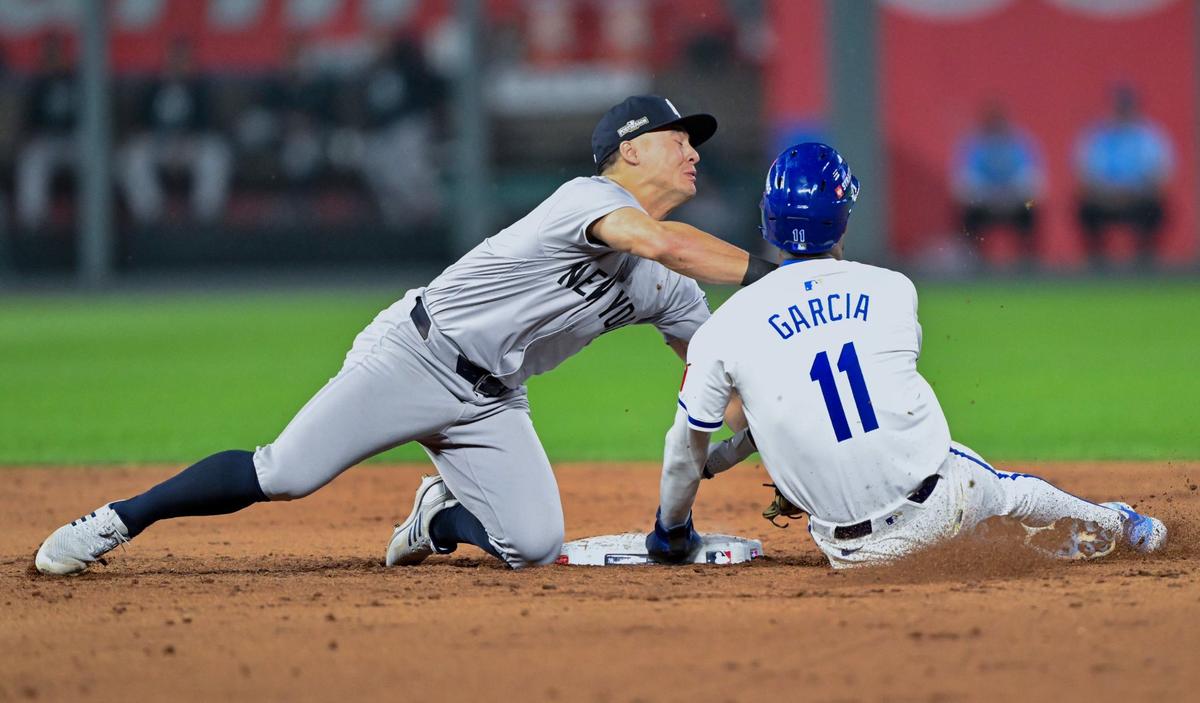 New York Yankees shortstop Anthony Volpe (11) tags Kansas City Royals third baseman Maikel Garcia (11) in the throat on a double play in the 6th inning during Game 4 of the American League Division Series on Thursday, Oct. 10, 2024, at Kauffman Stadium.