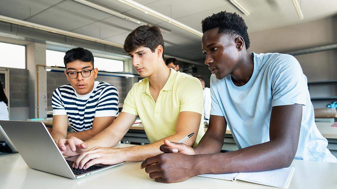 Teenager students working together at High School Classroom, doing exercise with laptop diverse diversity race multicultural education learn