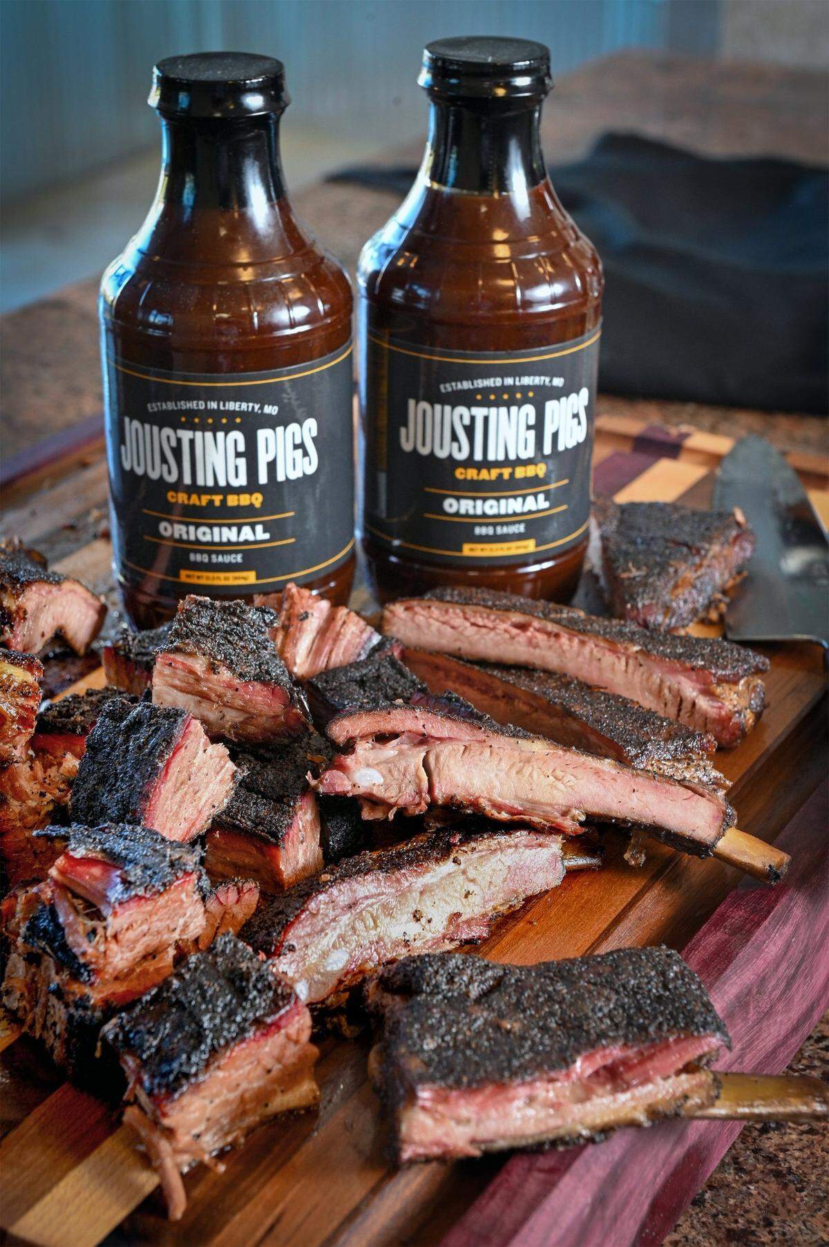John Atwell, co-owner of Jousting Pigs BBQ in Liberty, is expanding, taking over the former Arthur Bryants restaurant at 1702 Village West Parkway. Sliced ribs and burnt ends he smoked overnight in the new restaurant’s smoker are shown with their Jousting Pigs BBQ sauce.