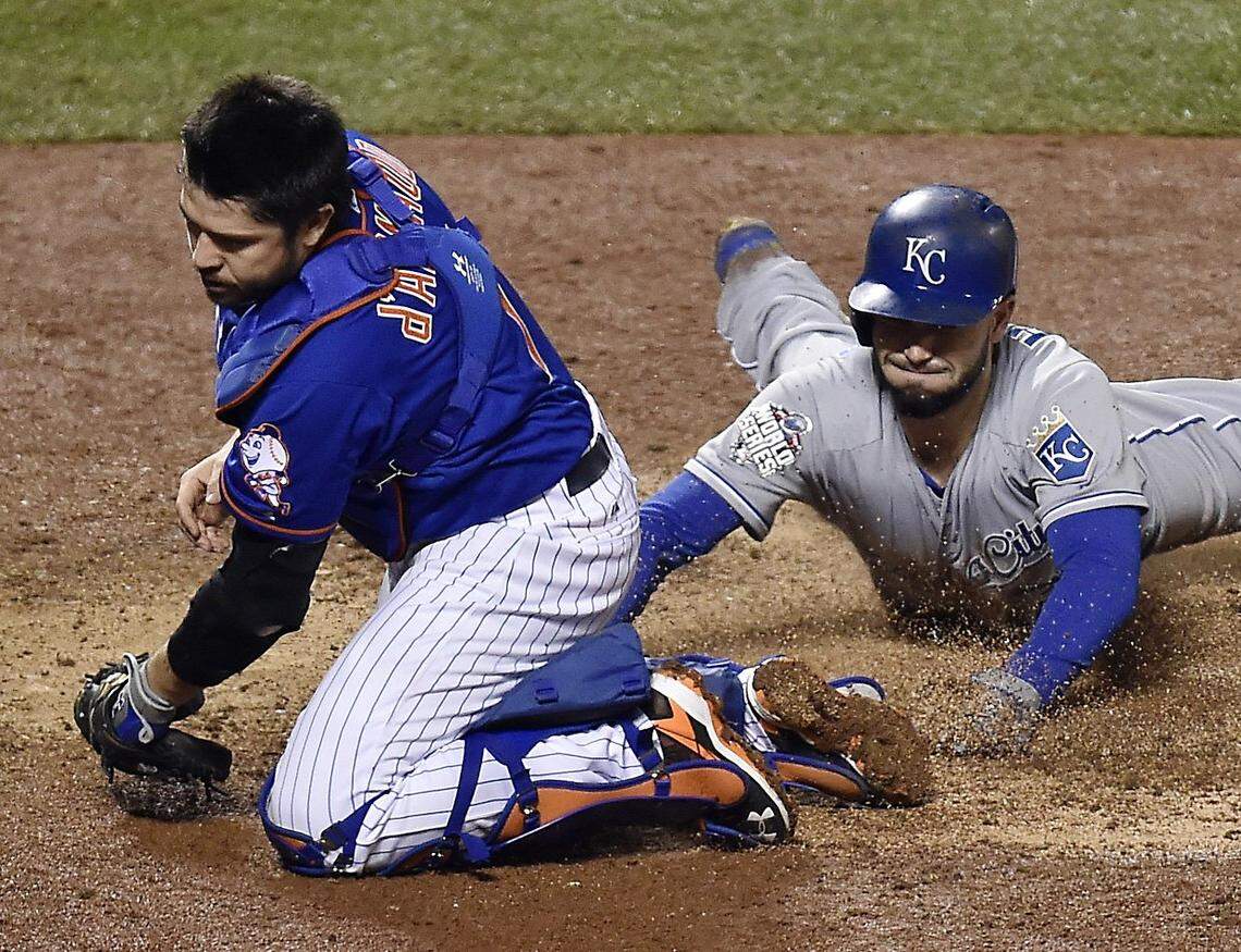 New York Mets catcher Travis d’Arnaud was pulled off home plate by a wide throw so he missed a chance to tag Kansas City Royals first baseman Eric Hosmer, who scored in the ninth inning during Game 5 of the World Series on Sunday, November 1, 2015 at Citi Field in New York.