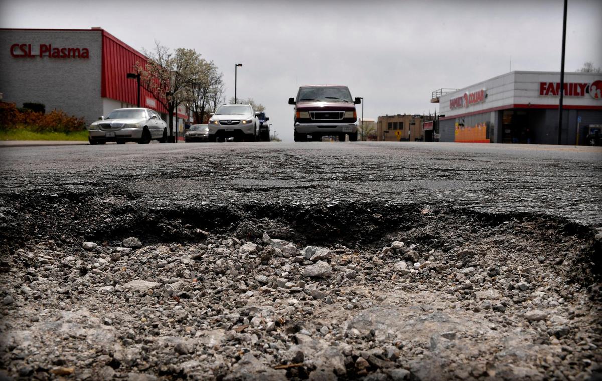 Drivers in the northbound lanes of Main Street near 37th Street, approach a large pothole in the middle of the road.