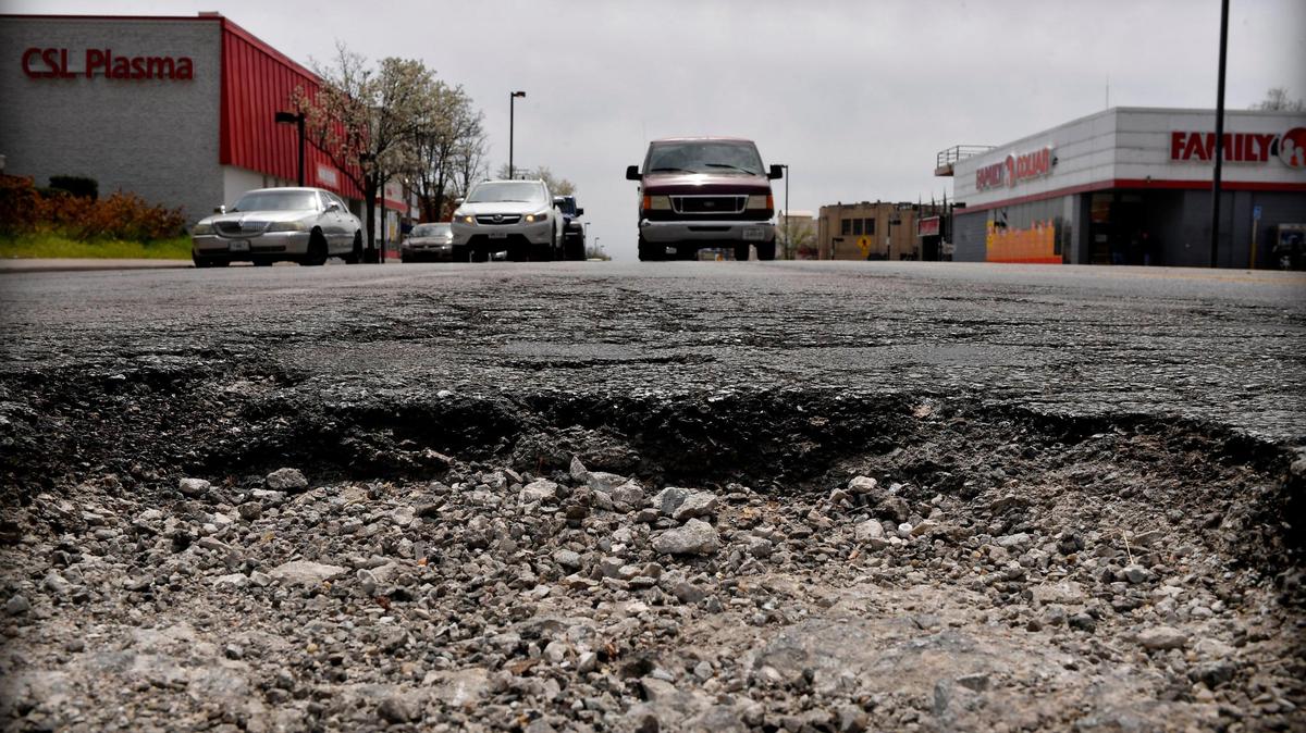 Drivers in the northbound lanes of Main Street near 37th Street, approach a large pothole in the middle of the road.