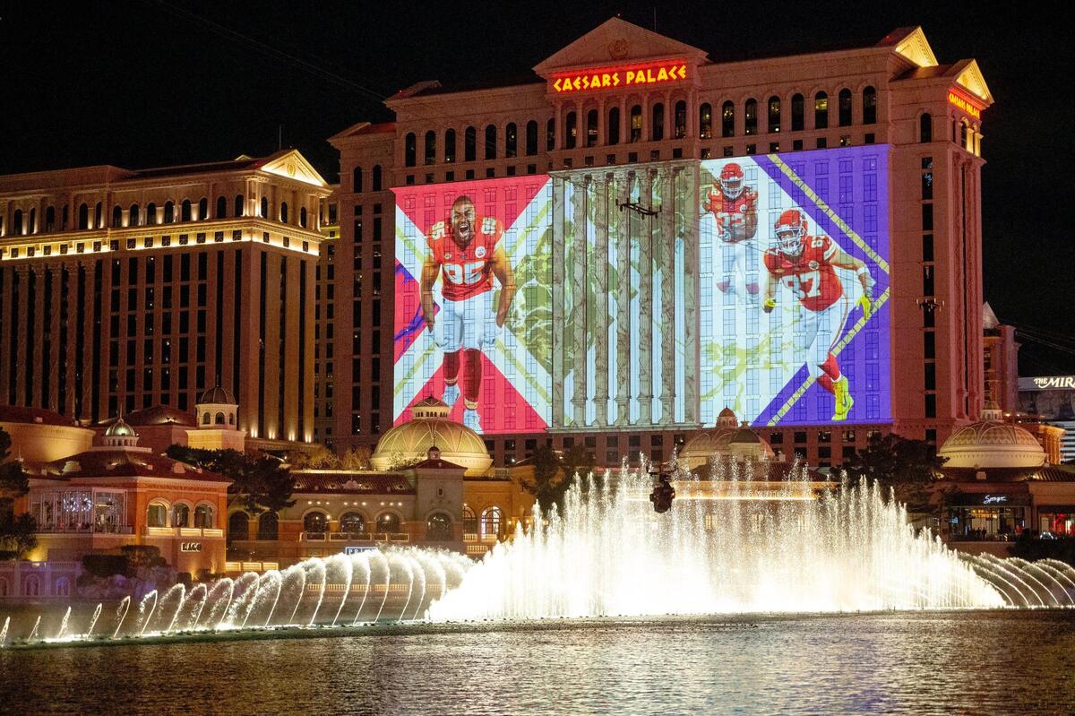 Super Bowl-themed murals were projected on the side of Caesars Palace where fans took in the sights including the fountains of Bellagio on Thursday, Feb. 8, 2024, in Las Vegas, Nevada.