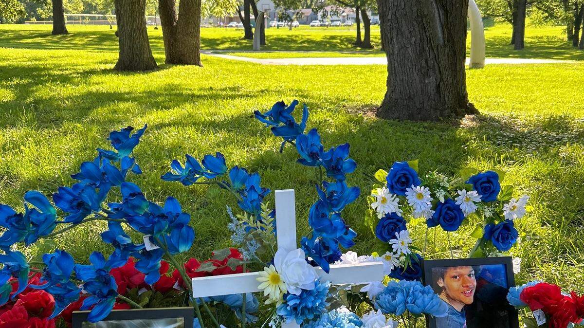 Family photos, flowers and prayer candles adorn a memorial display at a vigil for Benyamin Hawthorne, Jr. Hawthorne, 17, was fatally shot in a Kansas City park on May 16.