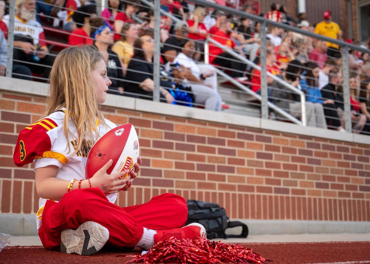 Elena Easley, an 8-year-old from Cambridge, Minnesota, watches the Kansas City Glory, the city’s semi-professional women’s full-contact tackle football team, during their home opener against Texas Elite on Saturday, March 29, 2025, at the Pembroke Hill School in Kansas City. Elena and her family were special guests of the team after a TikTok video of Elena went viral after a boy at her school told her girls don’t play football.
