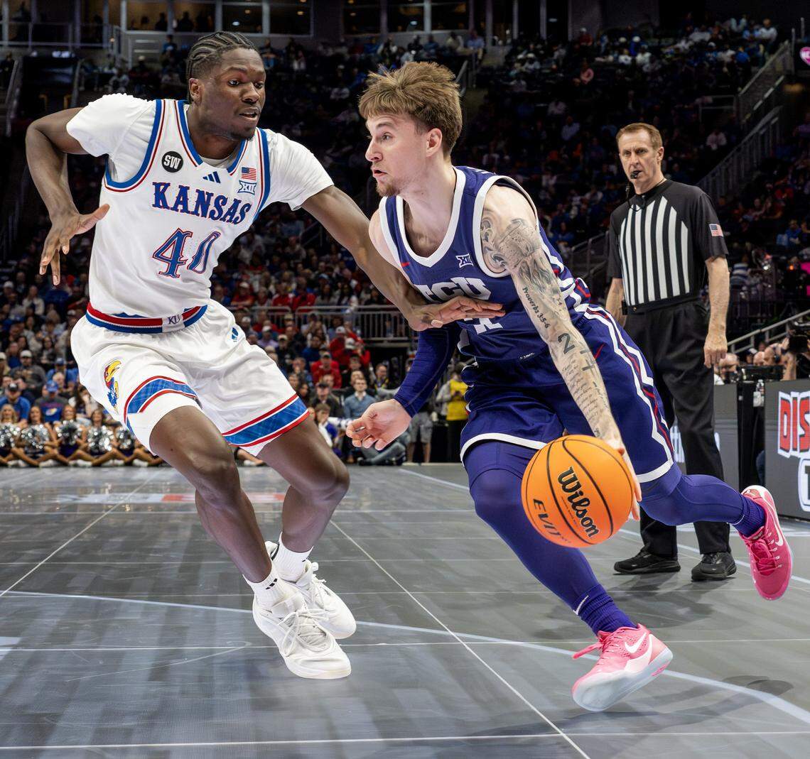 TCU Horned Frogs guard Brock Harding (2) shields the ball from Kansas Jayhawks forward Flory Bidunga (40) during the first half of a Big 12 Men’s Basketball Tournament game at T-Mobile Center on Thursday, March 12, 2026, in Kansas City.