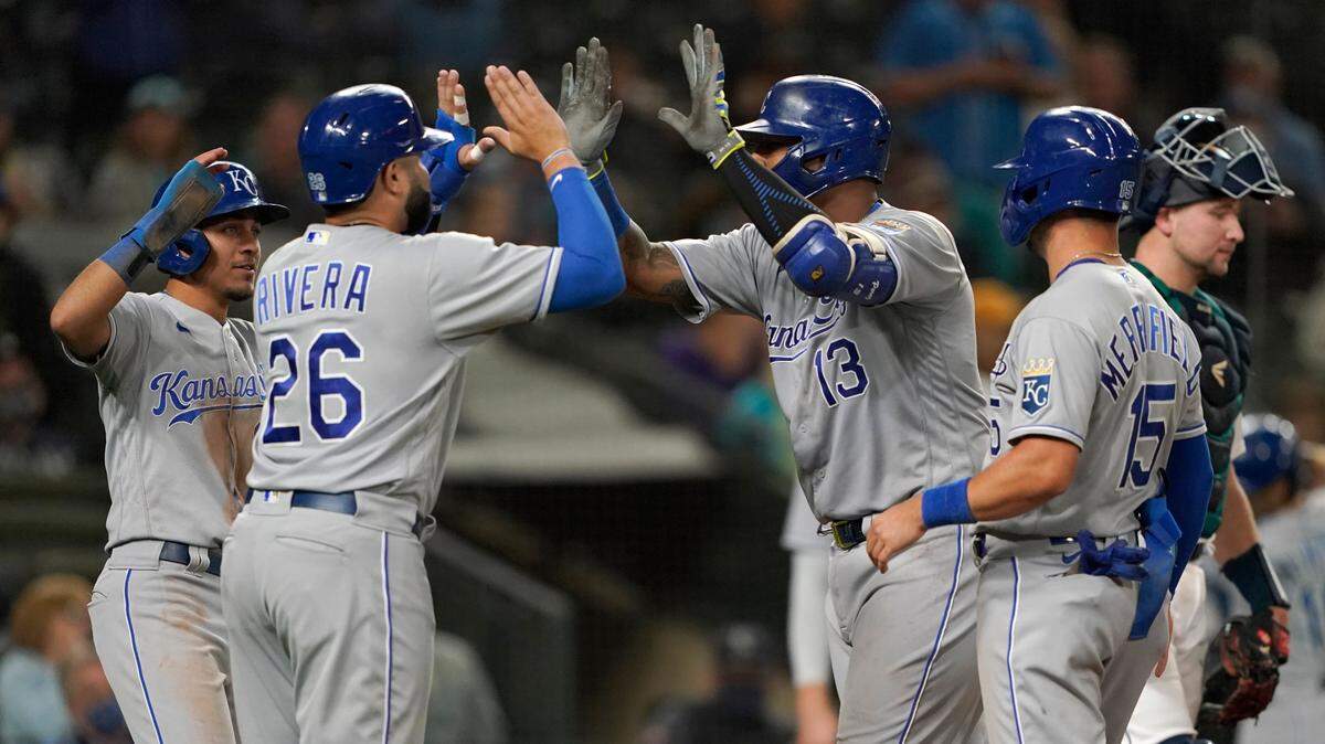 Kansas City Royals’ Salvador Perez (13) is greeted at the plate by Emmanuel Rivera (26) after Perez hit a grand slam against the Seattle Mariners during the sixth inning of a baseball game Thursday, Aug. 26, 2021, in Seattle. (AP Photo/Ted S. Warren)