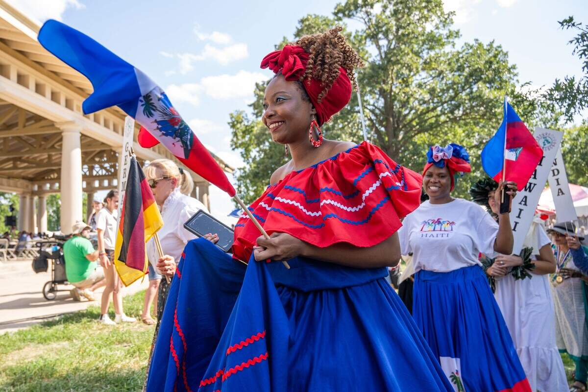 A woman representing Haiti walks in the parade of flags at the Ethnic Enrichment Festival in Swope Park on Saturday.