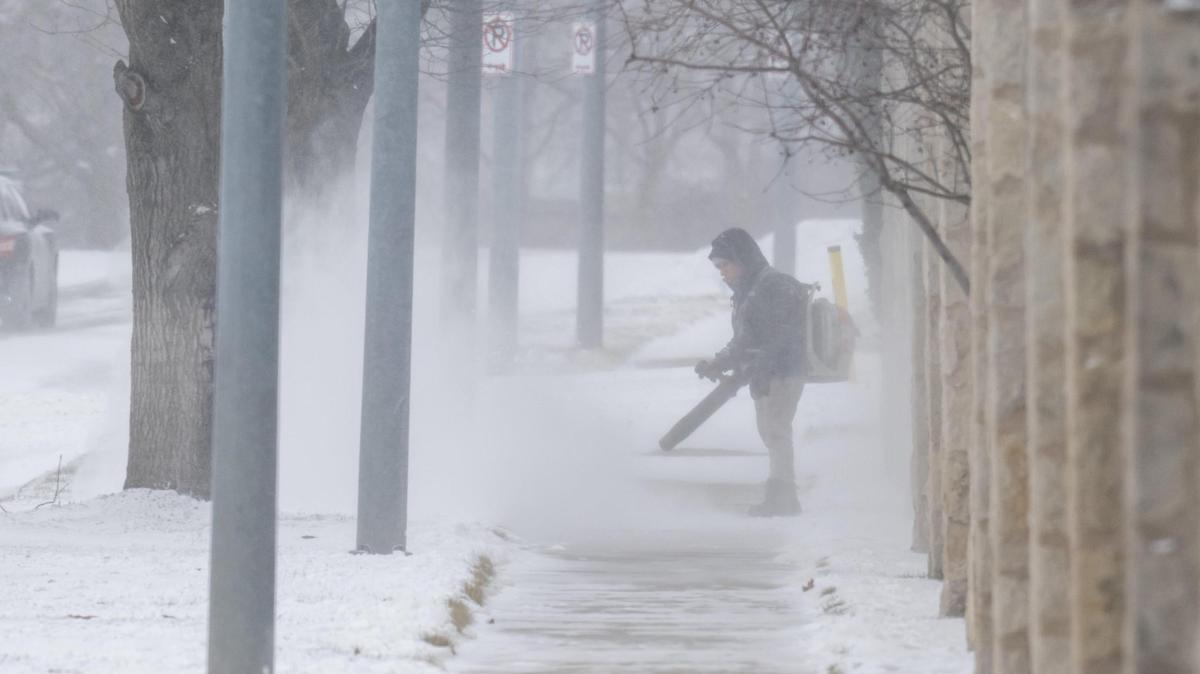 A landscape worker clears snow from a walking path using a snowblower on Tuesday, Feb. 18, 2025. Temperatures are expected to get barely above zero with dangerous wind chills through at least Thursday.