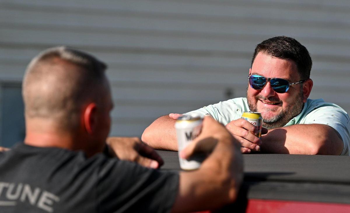 Kenyon Gleason, right, enjoys a cold beer on a very hot day with friend and fellow “Billard Boy” Russ Moore at Billard Municipal Airport in Topeka.
