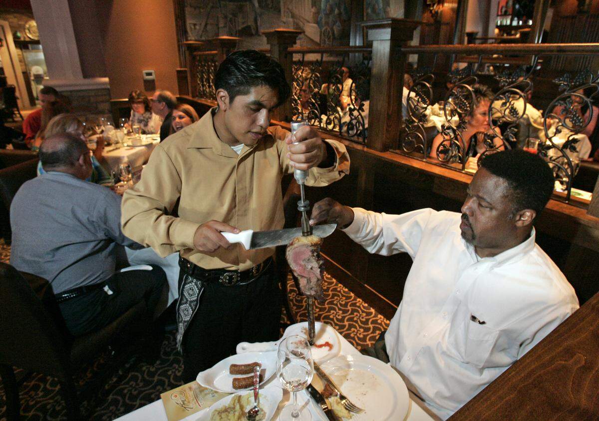 Victor Martinez, one of the meat servers at Neil Smith's Amor De Brazil, served slices of top sirloin to Brian Foster of Olathe in 2007.