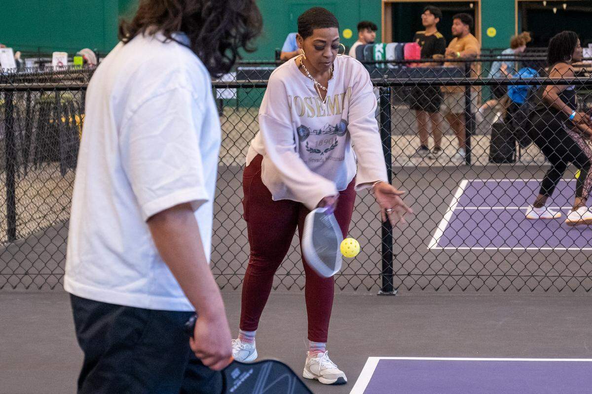 Yvonne Boyd-Alexander serves a wiffleball during a meeting of the Black Pickleball Club at SW19 at the Stadium, on Sunday, February 22, 2026, in Kansas City. The club, started by Brandan Jackson, hosts weekly meetups every Sunday as a space for Black people to participate in pickleball.