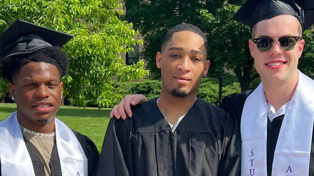Kansas point guard Dajuan Harris, middle, poses with guards Joseph Yesufu, left, and Michael Jankovich, right, on their graduation day at KU.