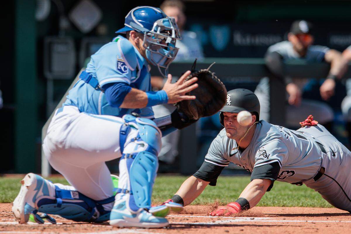 Chicago White Sox outfielder Andrew Benintendi dives into home plate during the fourth inning of Sunday’s game against the Kansas City Royals at Kauffman Stadium.