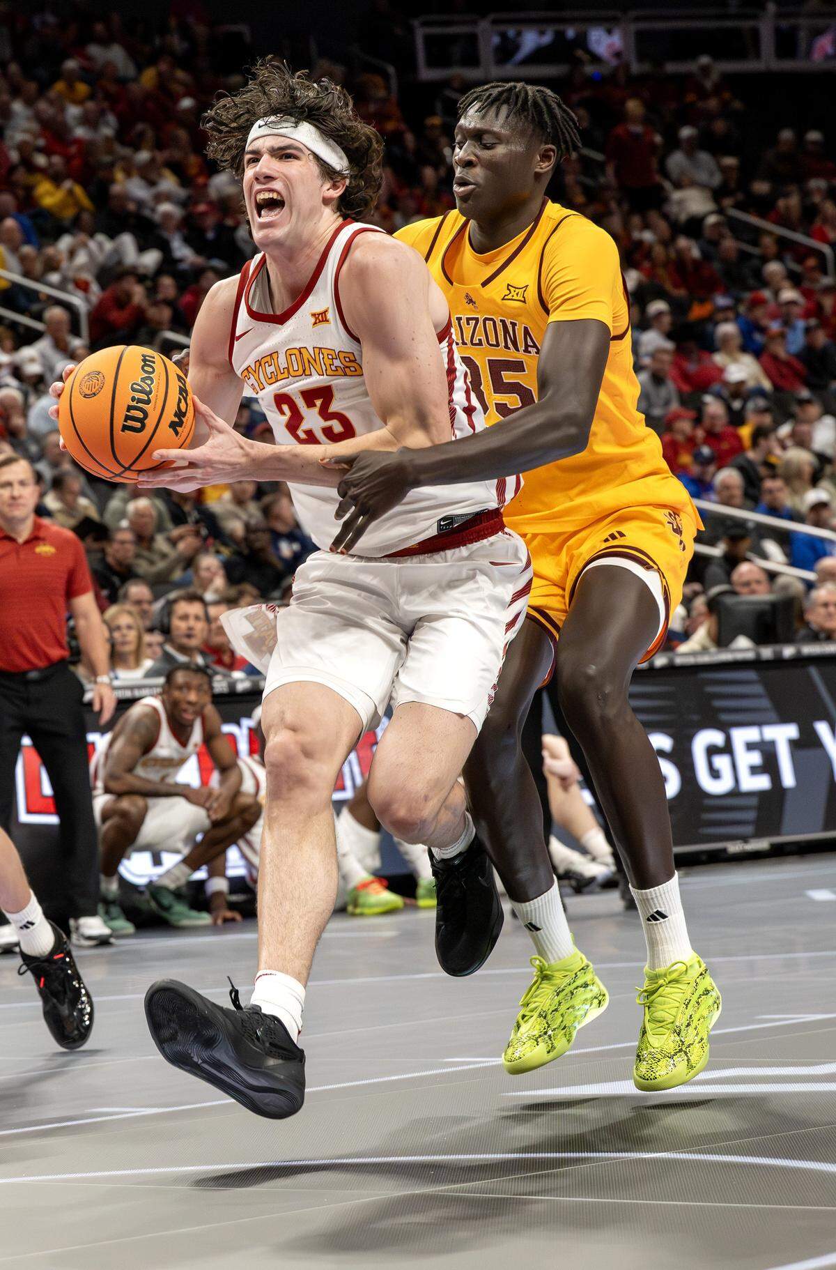 Iowa State forward Blake Buchanan (23) dribbles up court while shielding the ball from Arizona State center Massamba Diop (35) before attempting a layup during the second half of a Big 12 men's basketball tournament game at T-Mobile Center on Wednesday, March 11, 2026, in Kansas City.