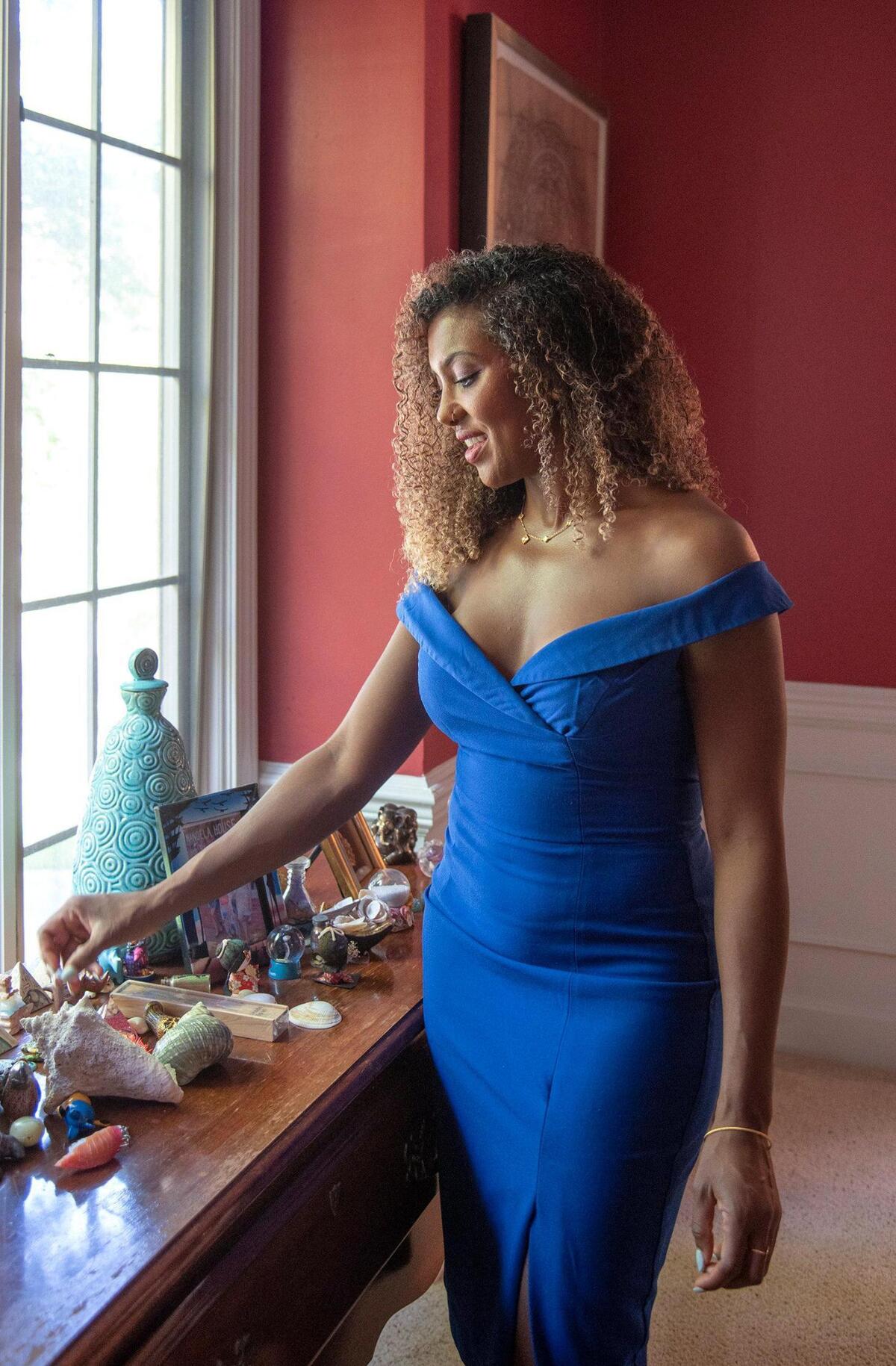 Dr. Meena Singh, a graduate of Harvard Medical School, returned to Kansas City to practice medicine. Here she shows her various mementos she has acquired from her trips to other countries.